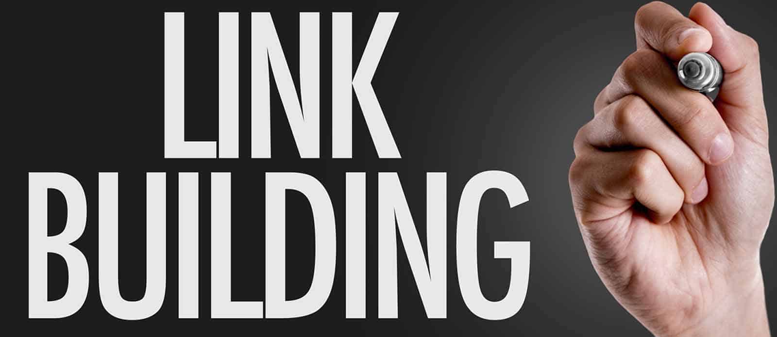 Hand writing the words Link Building with a marker