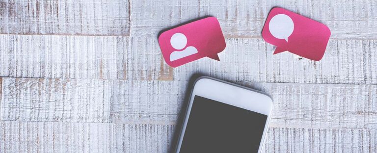 Smartphone below pink speech bubbles with profile icons