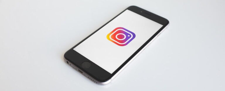 Smartphone on a white surface showing the Instagram logo