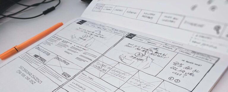 Hand-drawn website wireframes laid out on a desk