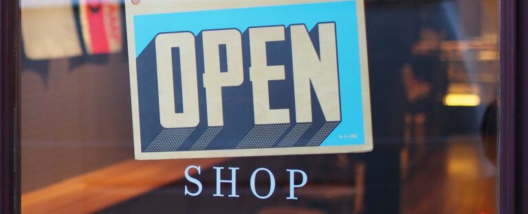 Open sign hanging in a shop window