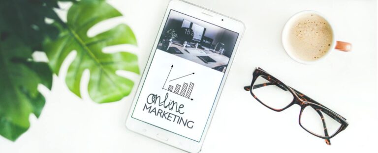 Tablet showing an online marketing growth sketch beside a coffee cup and glasses