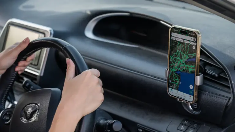 Driver following a map on a phone mounted on the car dashboard