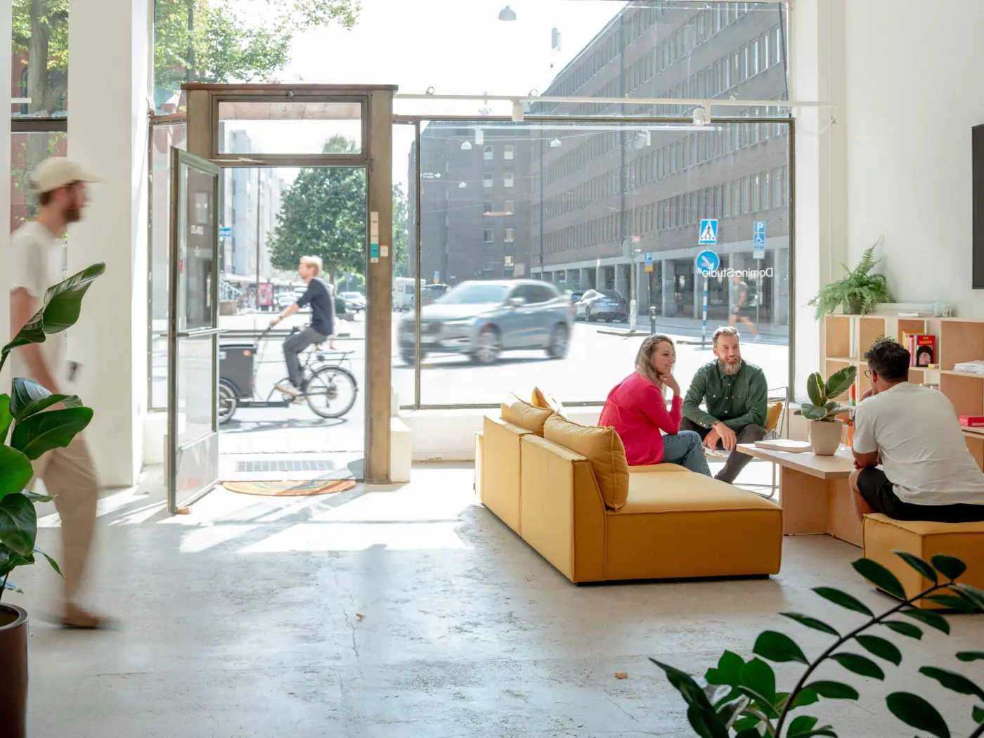 People relaxing on sofas in a bright, plant-filled brand studio