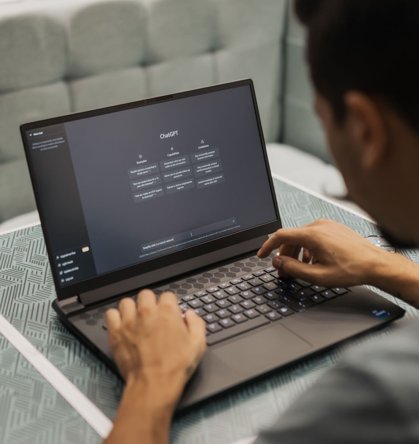 Man typing on a laptop with an AI chat assistant open on screen