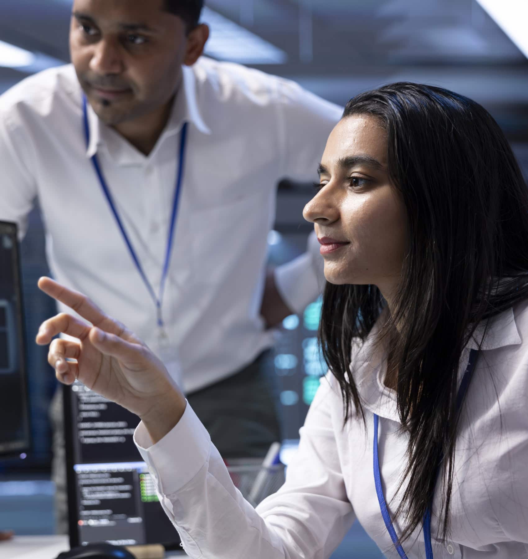 Two colleagues reviewing work together, one pointing at a screen