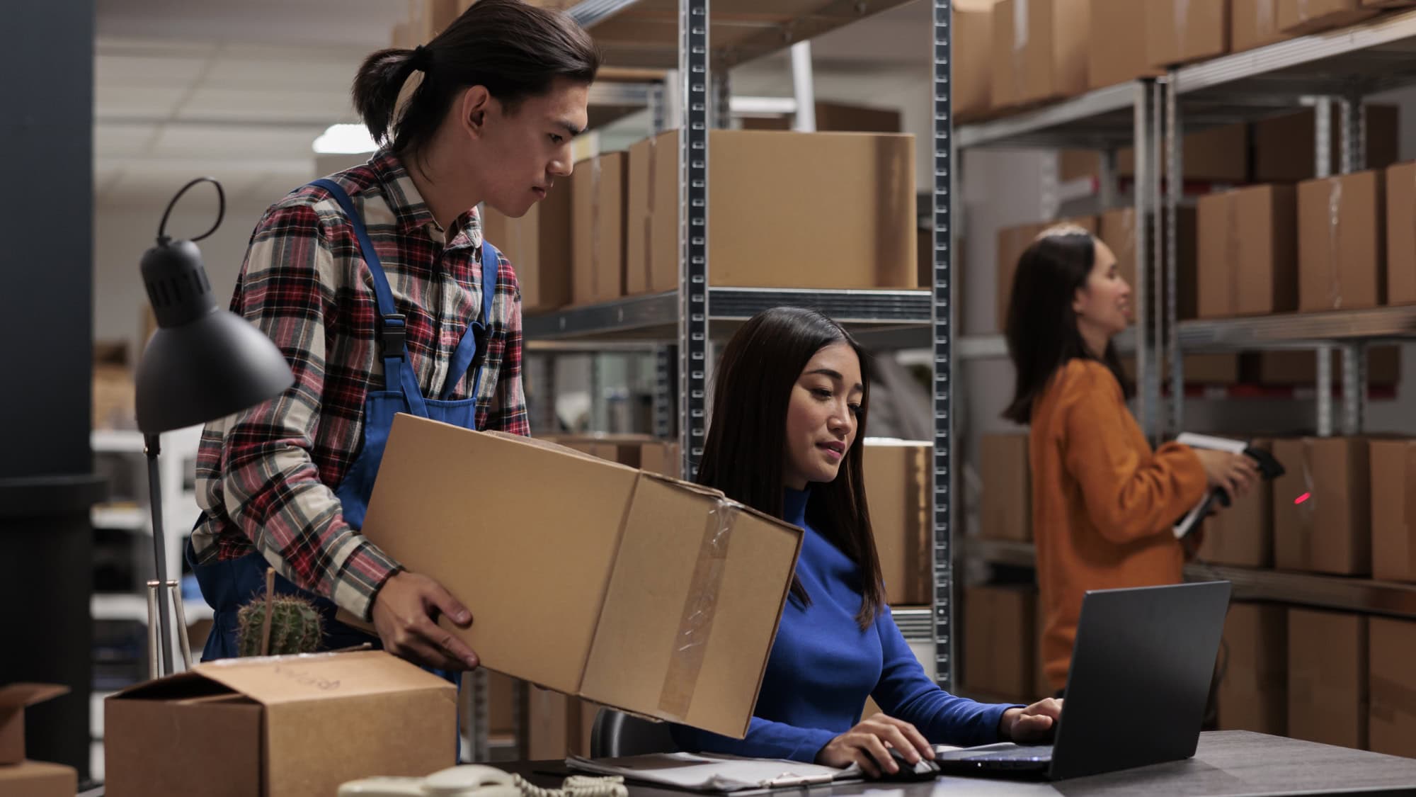 Small business team packing boxes and processing online orders in a stockroom