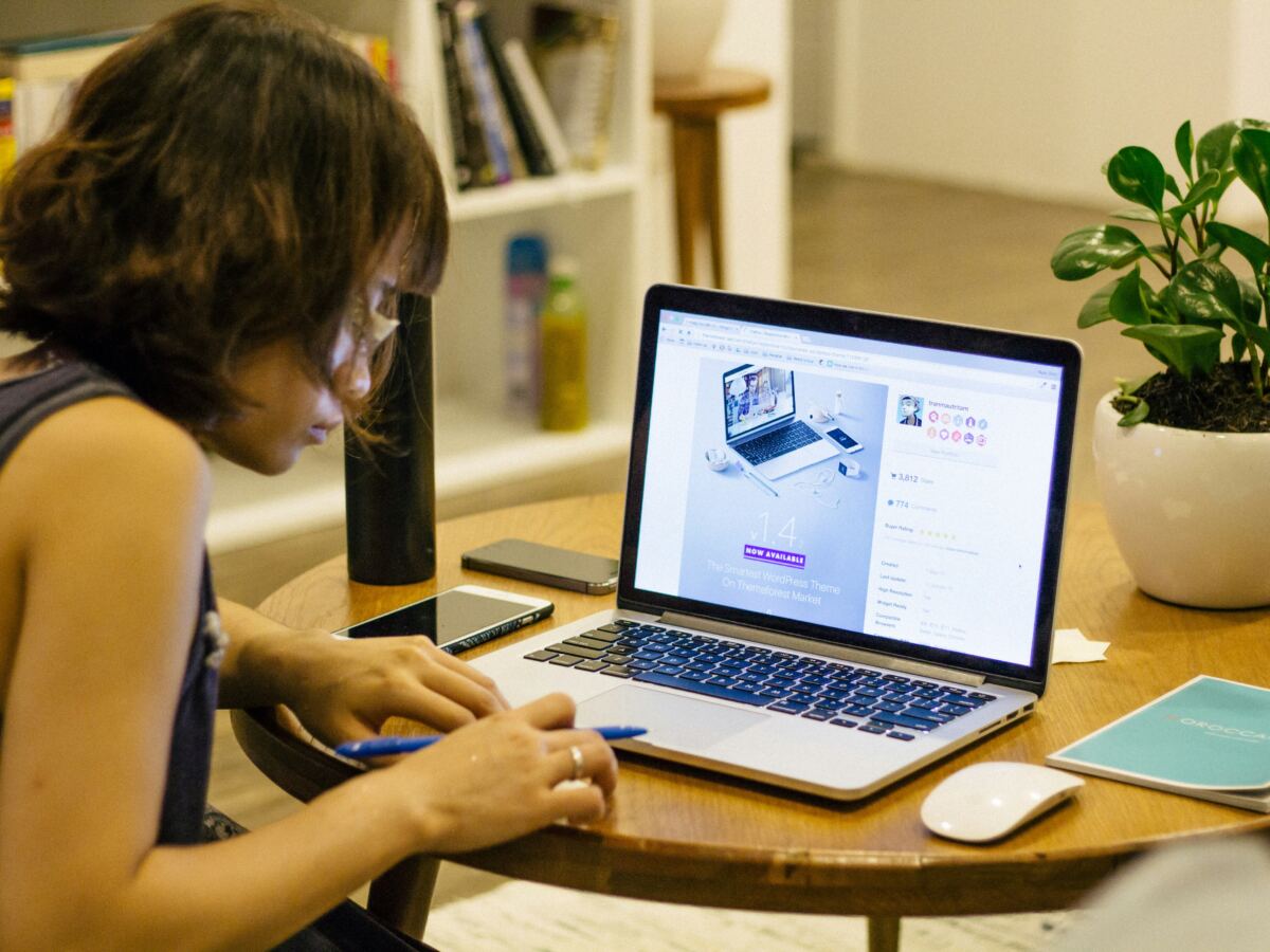 Woman browsing an online store on her laptop at a cafe table