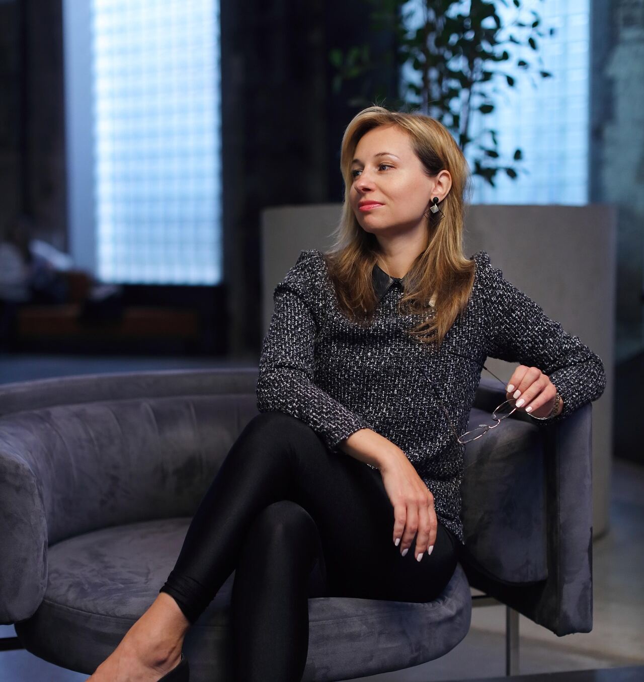 Businesswoman sitting in an armchair in a modern office lounge