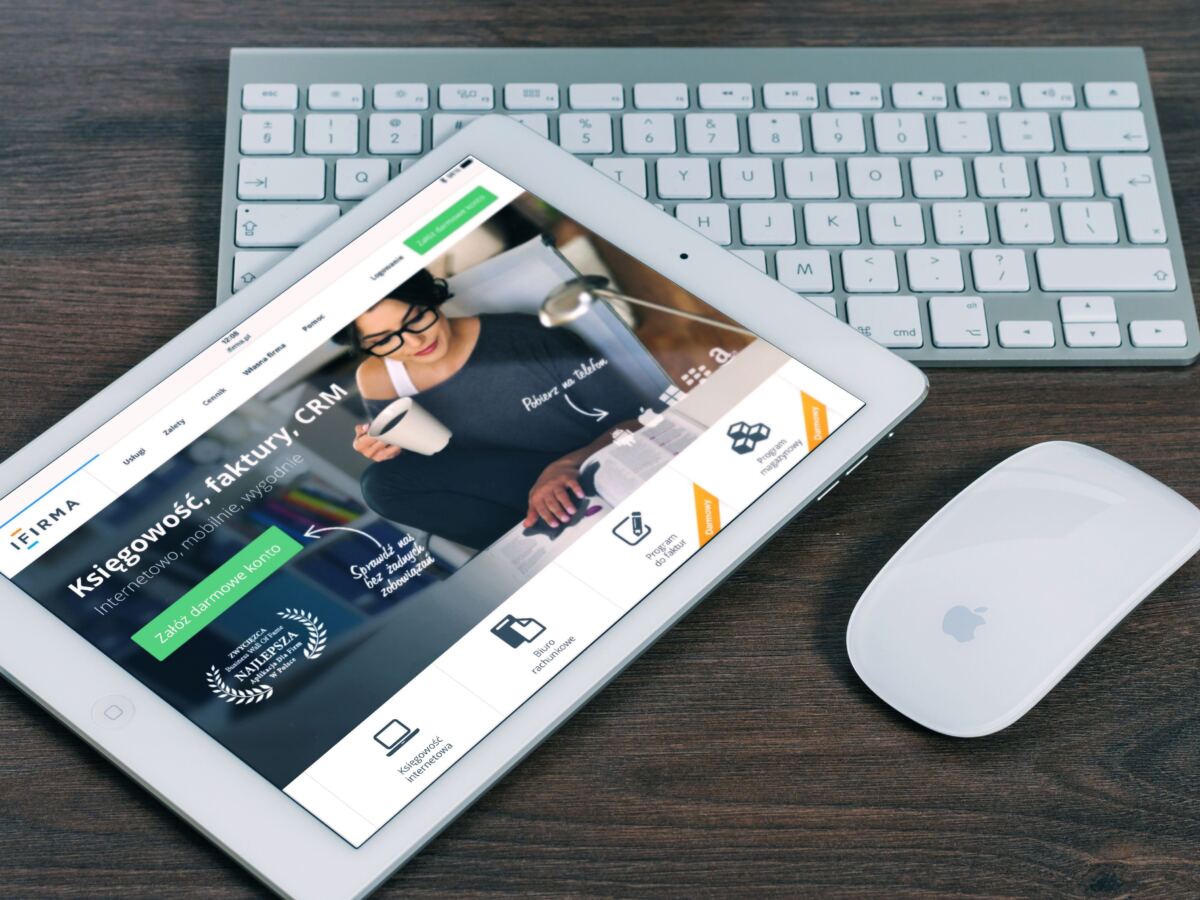 Tablet showing a website beside a wireless keyboard and mouse