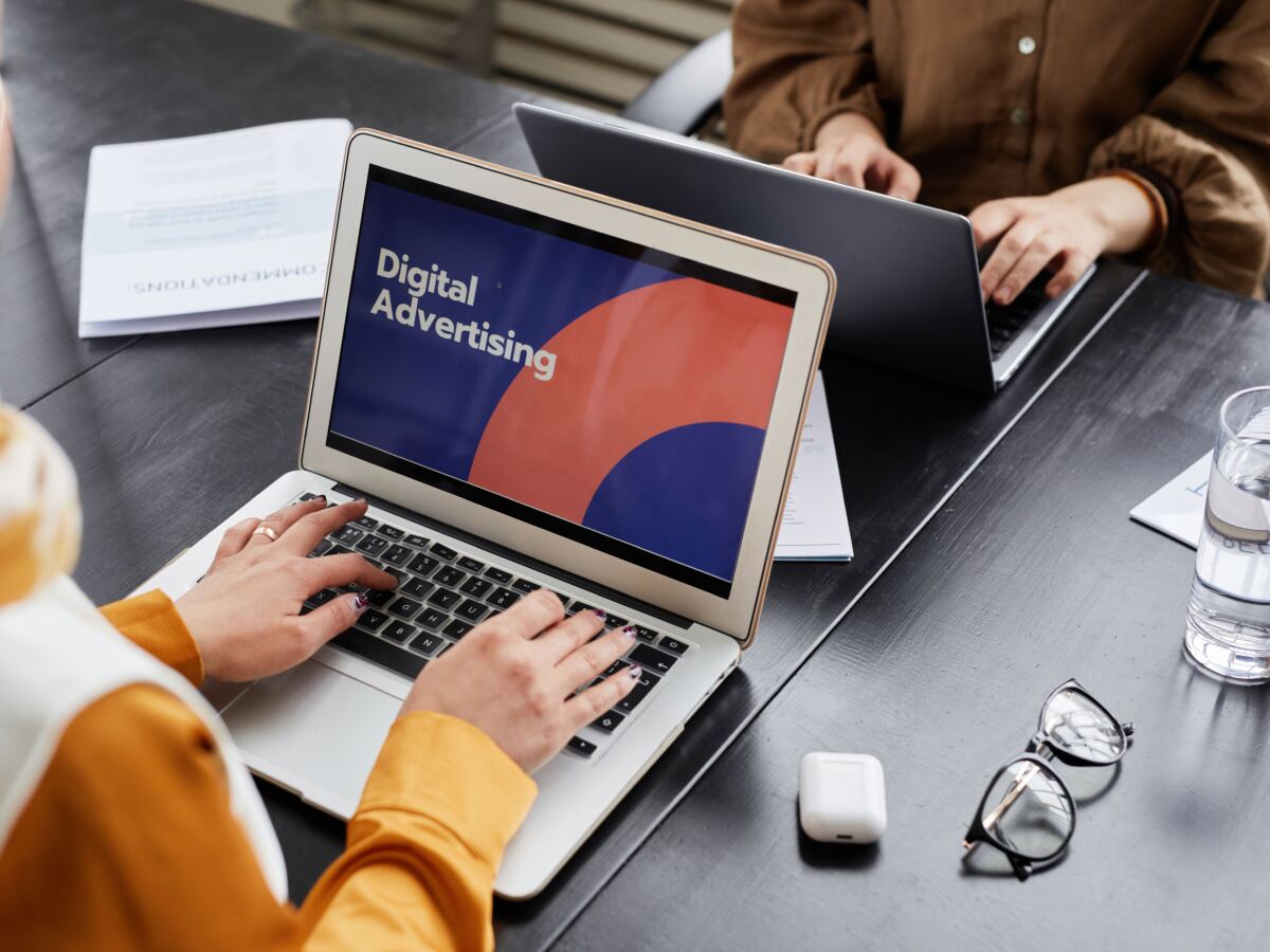 Laptop showing a digital advertising presentation on a shared desk