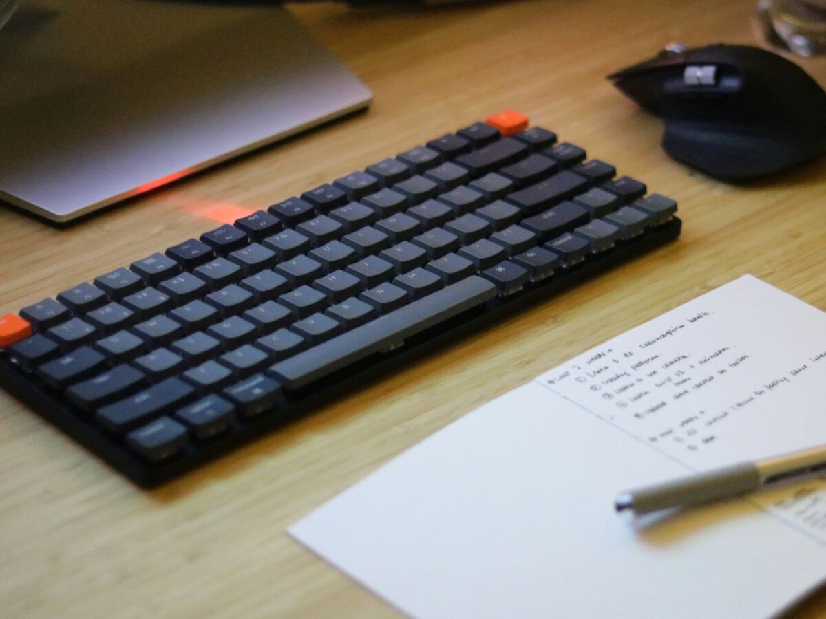 Desk with a keyboard, mouse, phone and handwritten notes